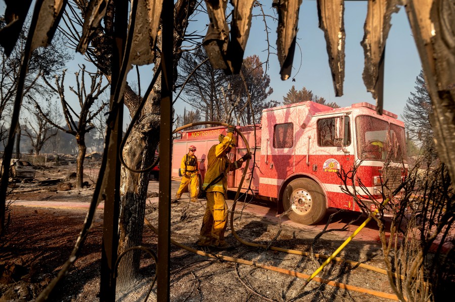 Firefighters mop up at Cache Creek Mobile Home Estates where the Cache Fire leveled dozens of residences on Wednesday, Aug. 18, 2021, in Clearlake, Calif. (AP Photo/Noah Berger)