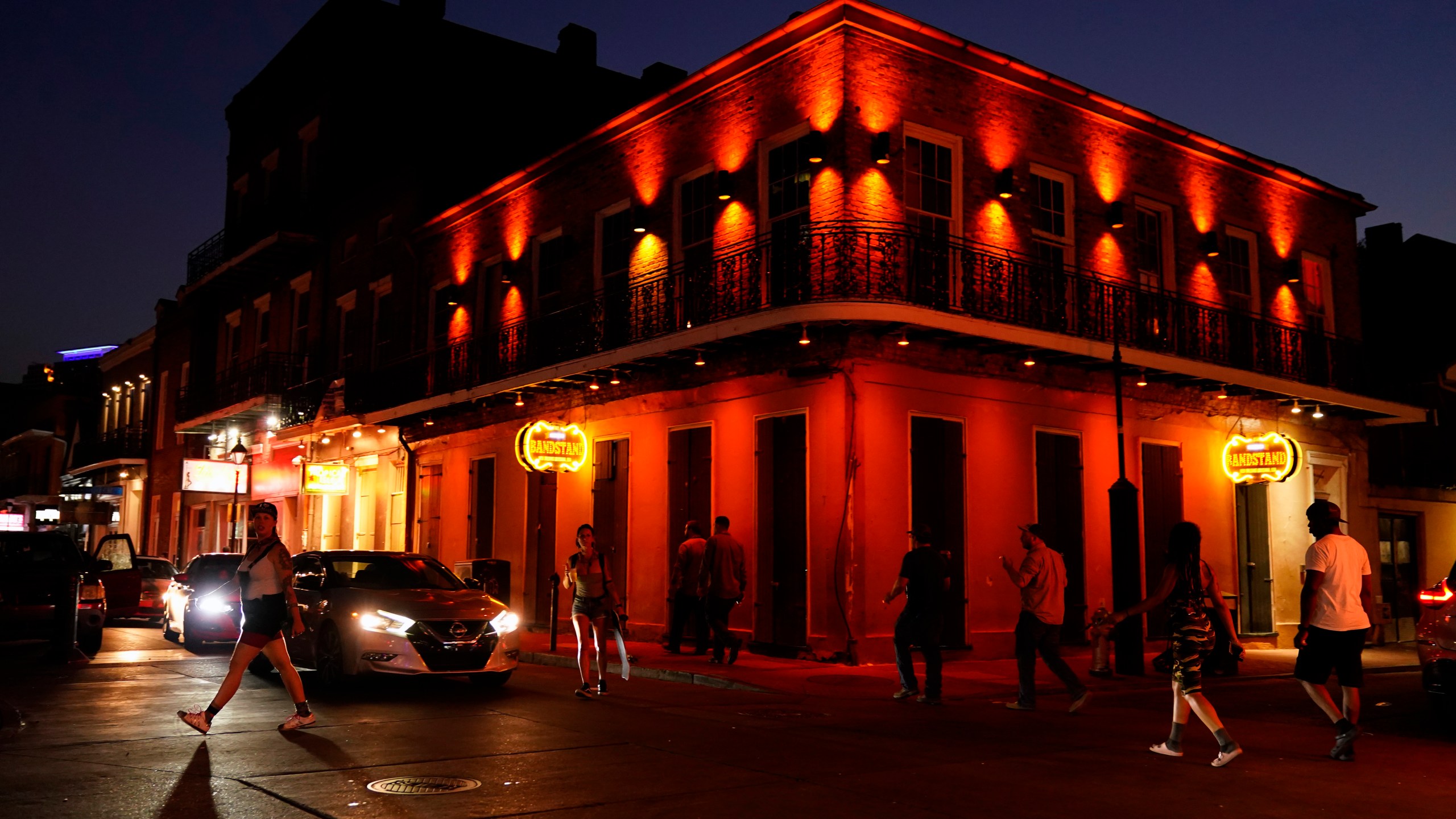 In the aftermath of Hurricane Ida, people walk across Bourbon Street, Saturday, Sept. 4, 2021, in the French Quarter of New Orleans. (AP Photo/Matt Slocum)