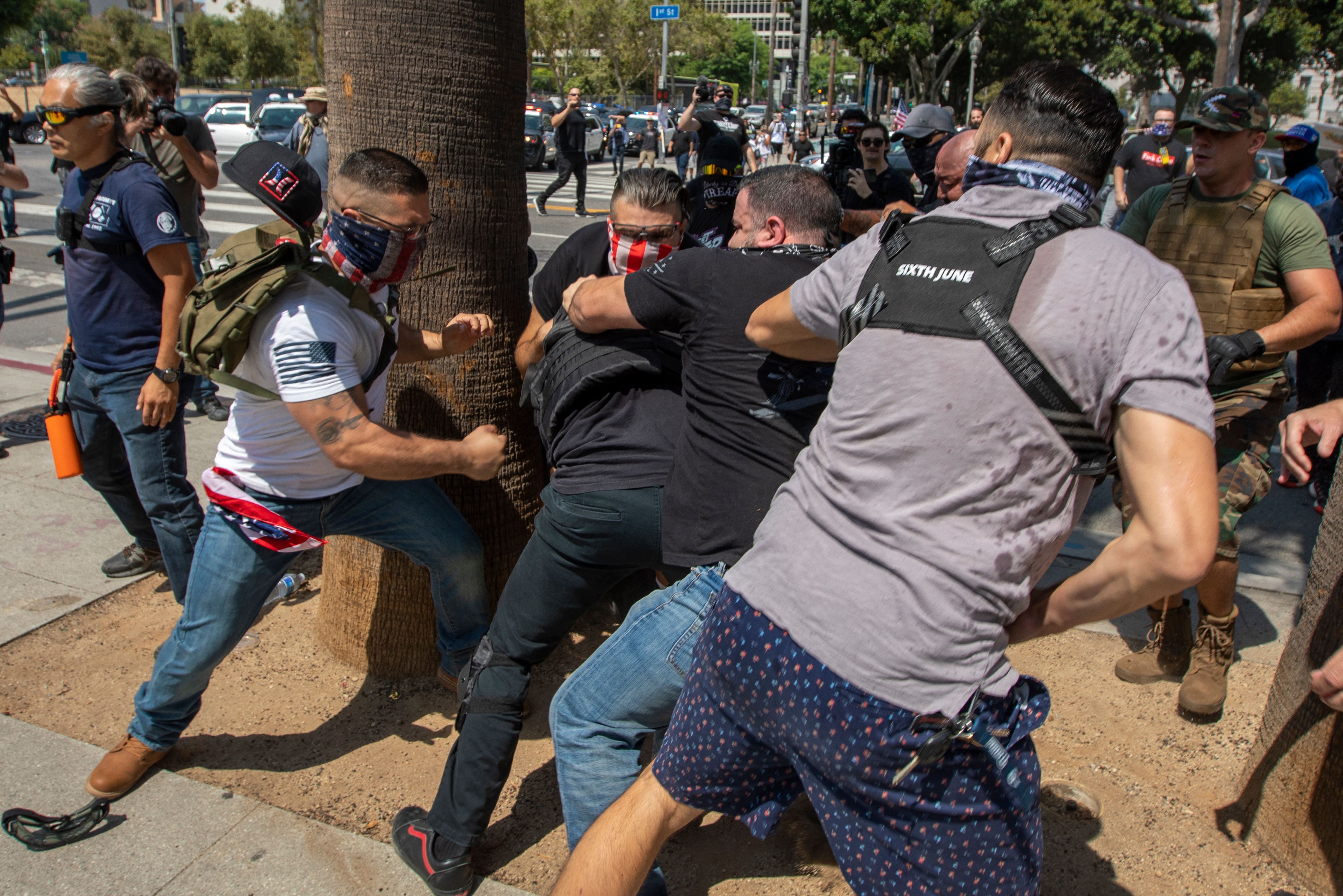 Anti-vaccination protesters beat up a counter protester during an anti-vaccination rally near City Hall following the Los Angeles City Council vote earlier this week to draw up an ordinance to require proof of vaccination to enter many public indoor spaces in Los Angeles, California on August 14, 2021. (DAVID MCNEW/AFP via Getty Images)