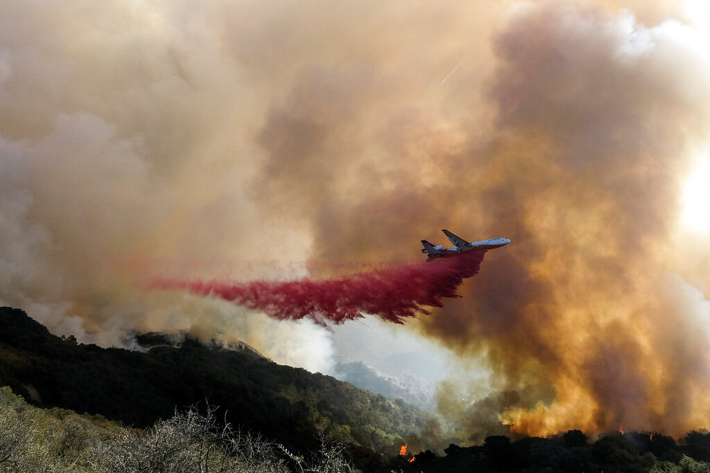 An air tanker drops retardant on a wildfire Wednesday, Oct. 13, 2021, in Goleta, Calif. (AP Photo/Ringo H.W. Chiu)