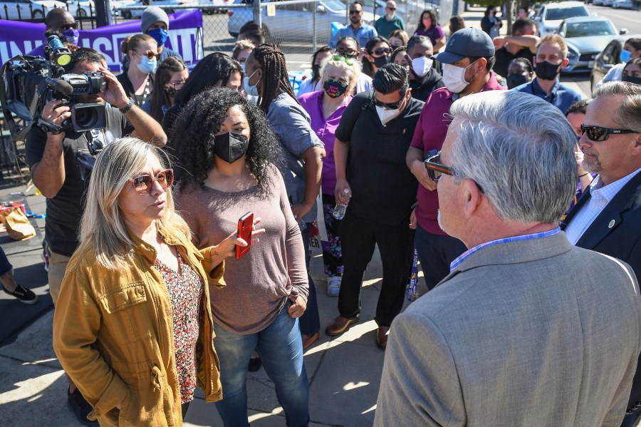 Fresno County social worker Lorraine Ramirez, left, discusses the situation with housing foster youth within the Child Protective Services office in downtown Fresno, Calif., with Fresno County Administrative Officer Jean Rousseau, right, during a demonstration and news conference by social workers represented by SEIU Local 521 on Thursday, Oct. 14, 2021. Rousseau is vowing changes after a news report revealed that some children removed from their families and into state care were living in deplorable conditions at the main child protective office, sleeping on conference tables and urinating into water bottles. (Craig Kohlruss/The Fresno Bee via AP)