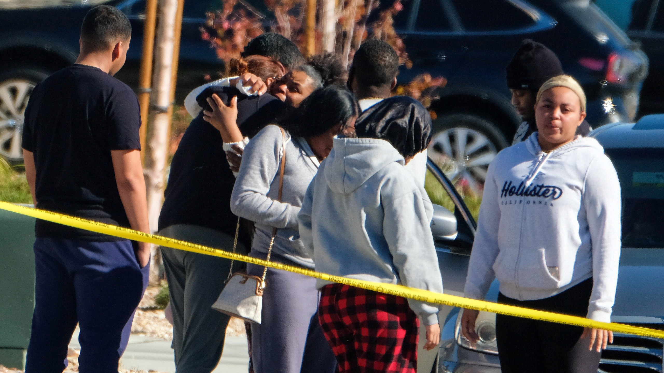 Neighbors react near a home where five bodies were found dead, in the city of Lancaster in the high desert Antelope Valley north of Los Angeles, Monday, Nov. 29, 2021. A Los Angeles County Sheriff's Department statement says deputies found a woman, a girl and three boys with gunshot wounds and paramedics pronounced them dead at the scene. The department says the children's father showed up at the Lancaster sheriff's station and was arrested on suspicion of five murders after being interviewed by detectives. (AP Photo/Ringo H.W. Chiu)