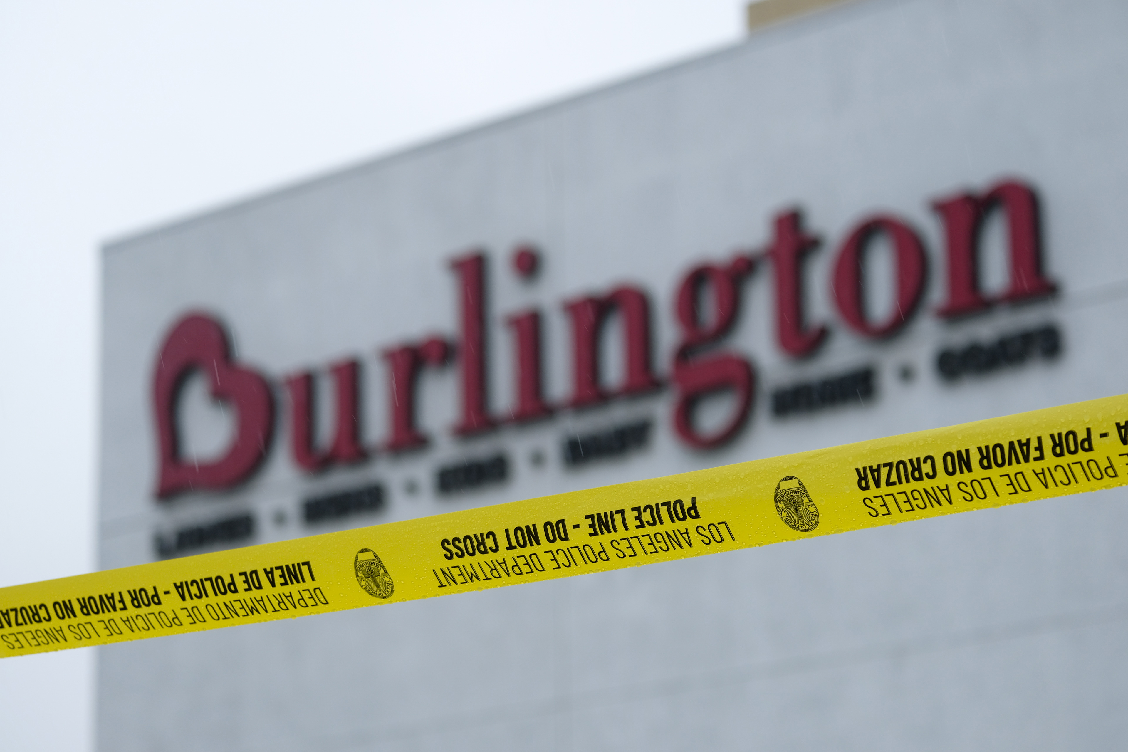 A police yellow tape is seen at the scene where two people were struck by gunfire in a shooting at the Burlington Coat Factory store in North Hollywood, Calif. on Dec. 23, 2021. (AP Photo/Ringo H.W. Chiu)