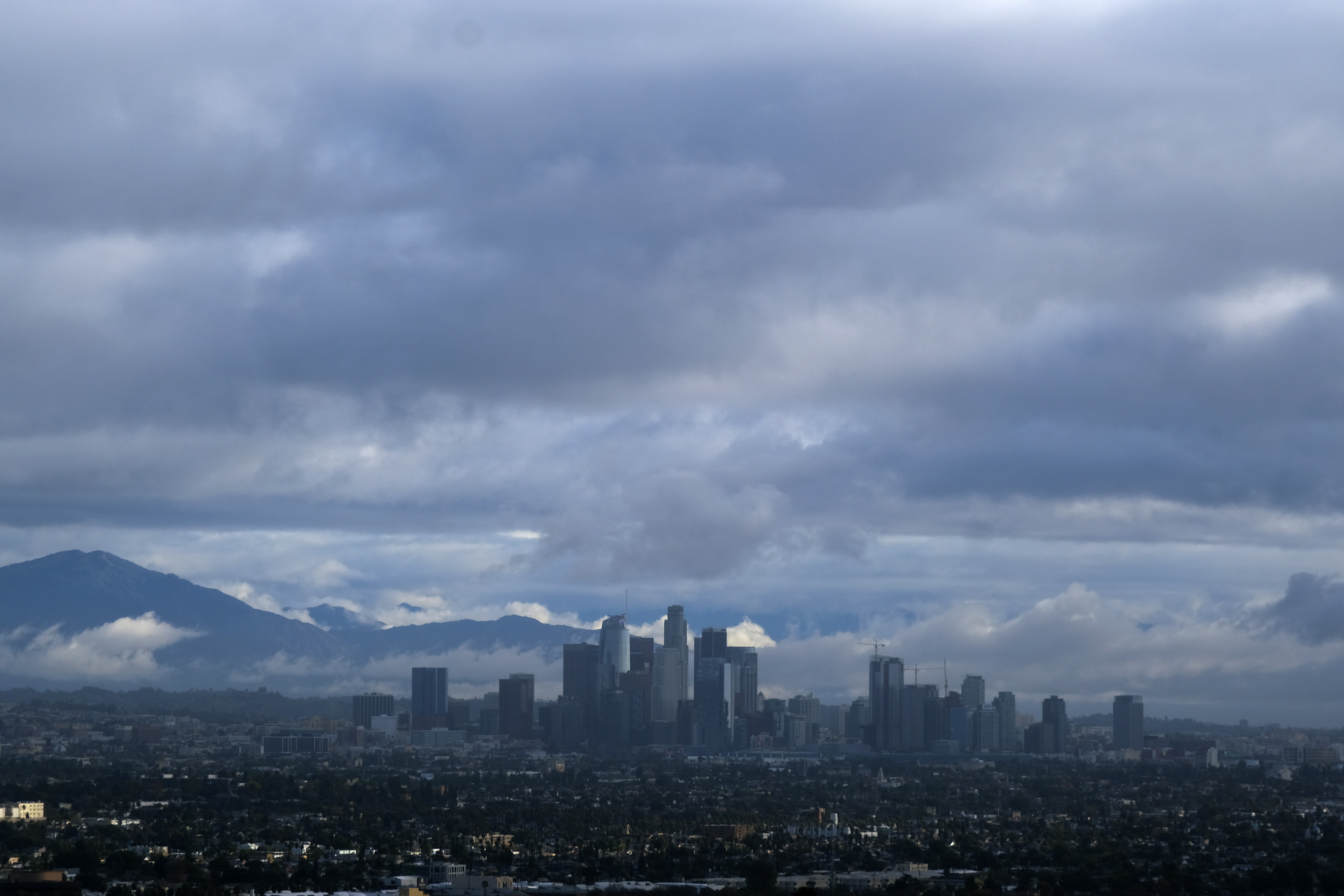 Storm clouds blanket the Los Angeles skyline is seen from Kenneth Hahn State Recreation Area on Dec. 24, 2021. (Ringo H.W. Chiu/Associated Press)