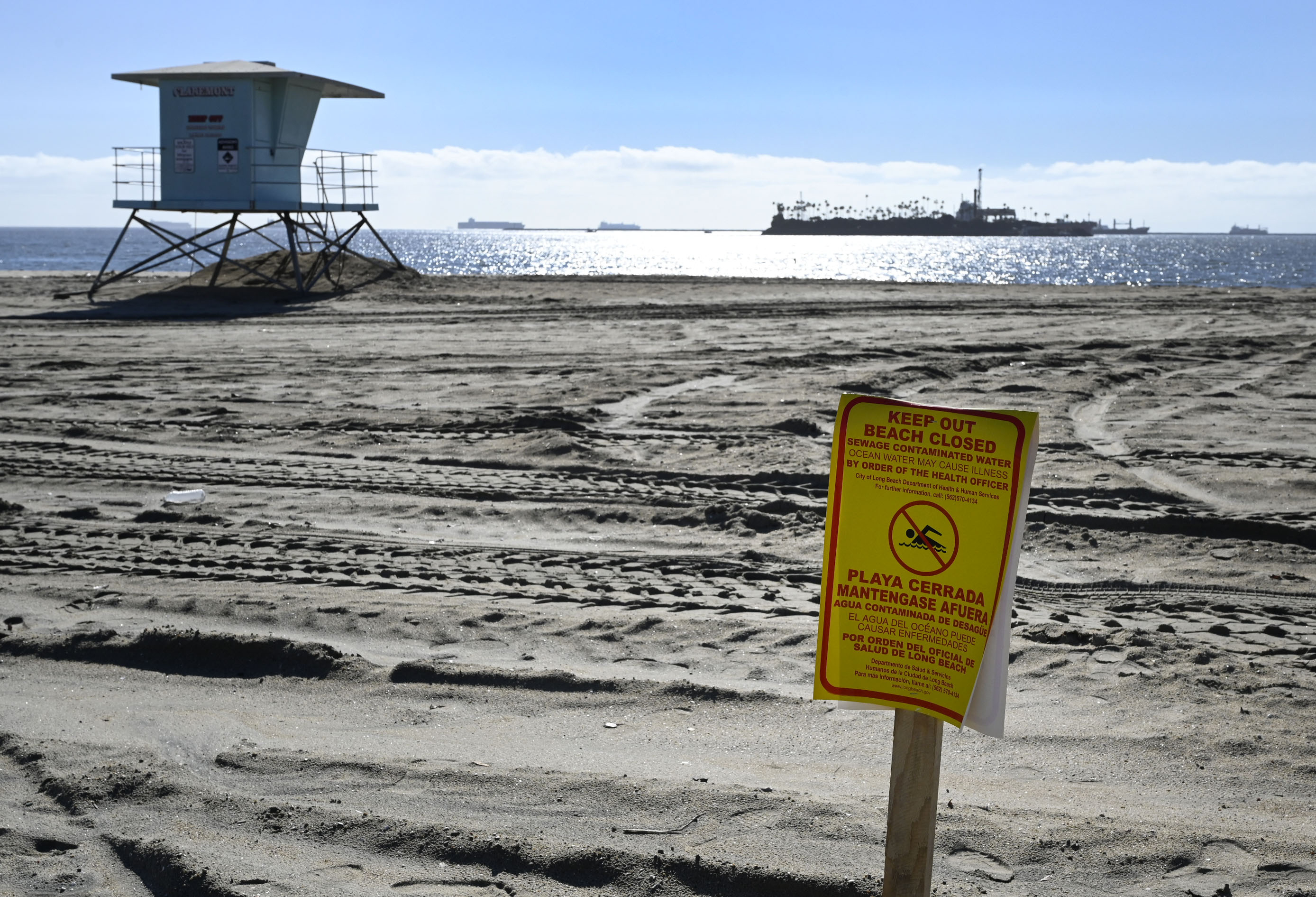 The release of millions of gallons of untreated sewage into the Dominguez Channel in Carson, Calif. on Friday, Dec. 31, 2021, has forced the closures of some beaches. This beach closure sign posted at the Granada Beach boat launch ramp was the only sign posted before 1 p.m. (Brittany Murray/The Orange County Register via AP)