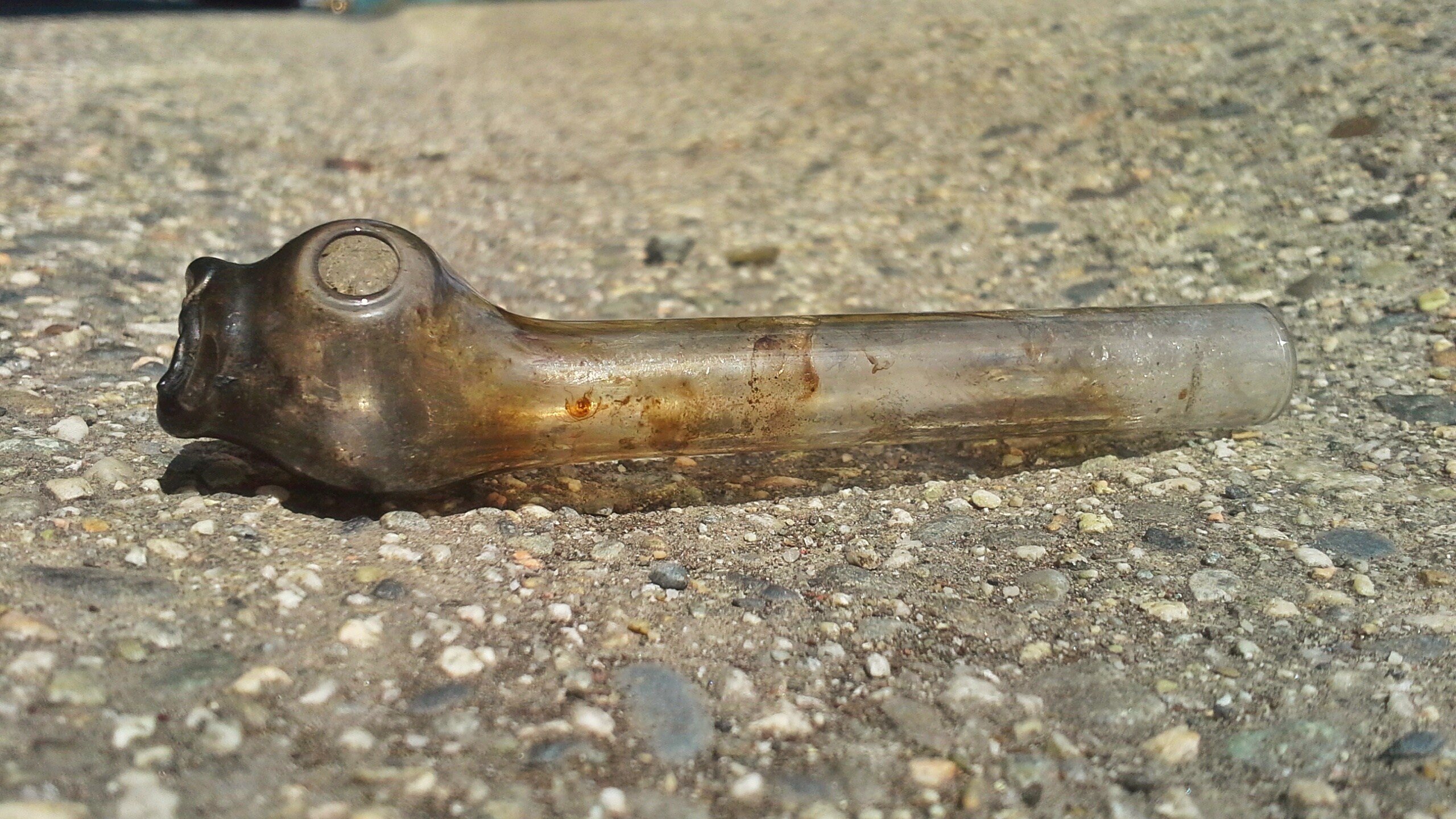 A dirty glass crack pipe lies in the gutter at the side of the road in this file photo. (iStock/Getty Images Plus)