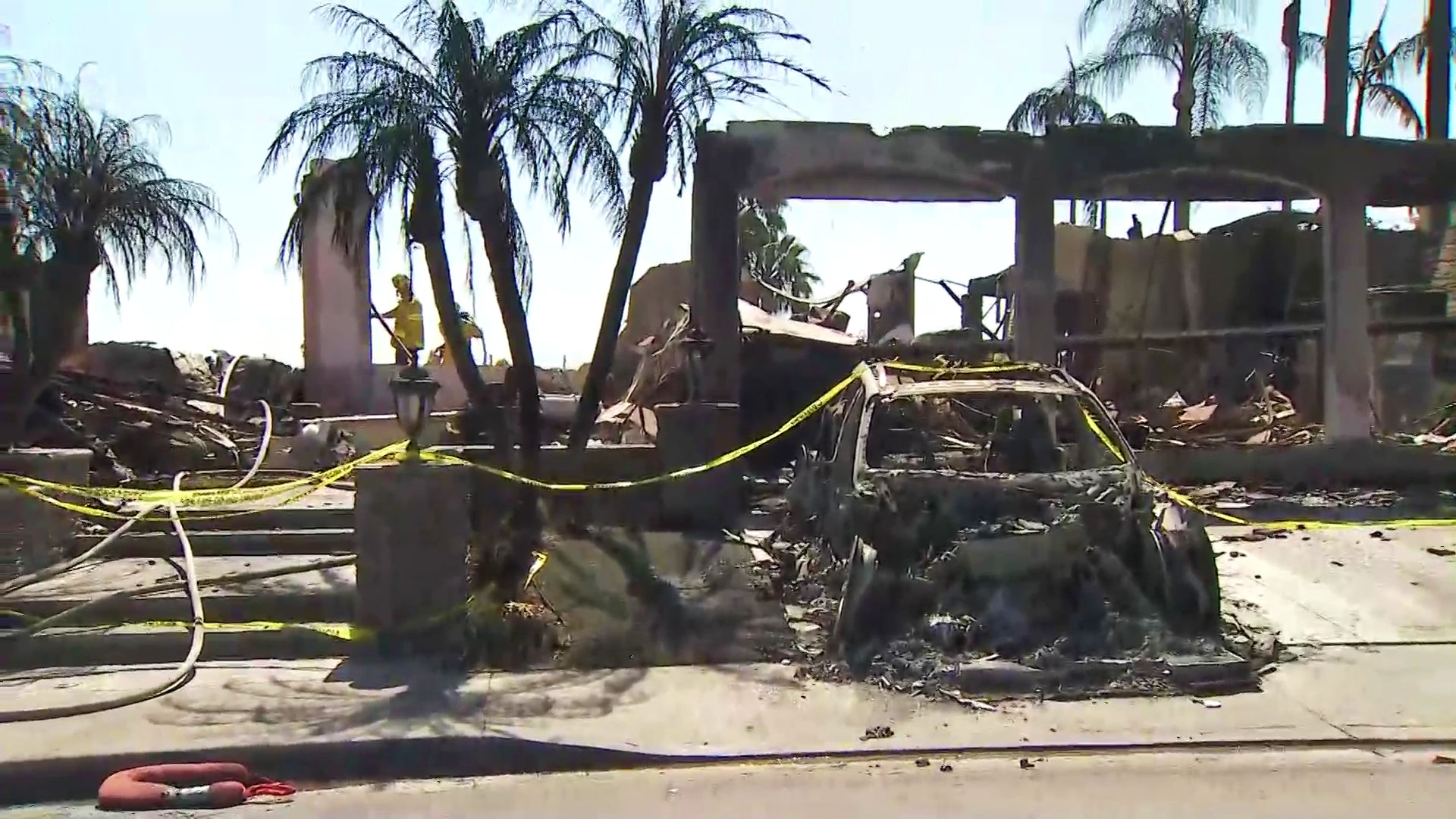 A burned car is seen in front of a fire-ravaged home in the Coronado Pointe community of Laguna Niguel on May 13, 2022. (KTLA)