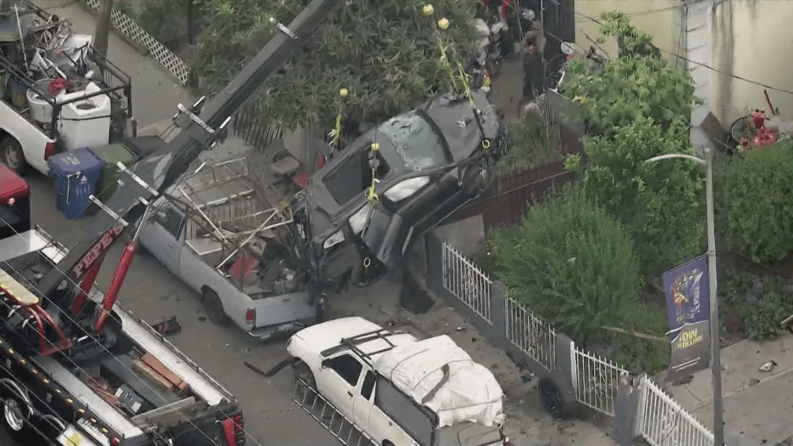 A car is being lifted from a crash scene in Watts on June 30, 2022. (KTLA)