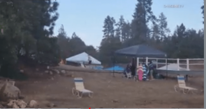 Survilance photo from Lake Arrowhead showing people packing up their belongings as the rain comes down. (OneScene)