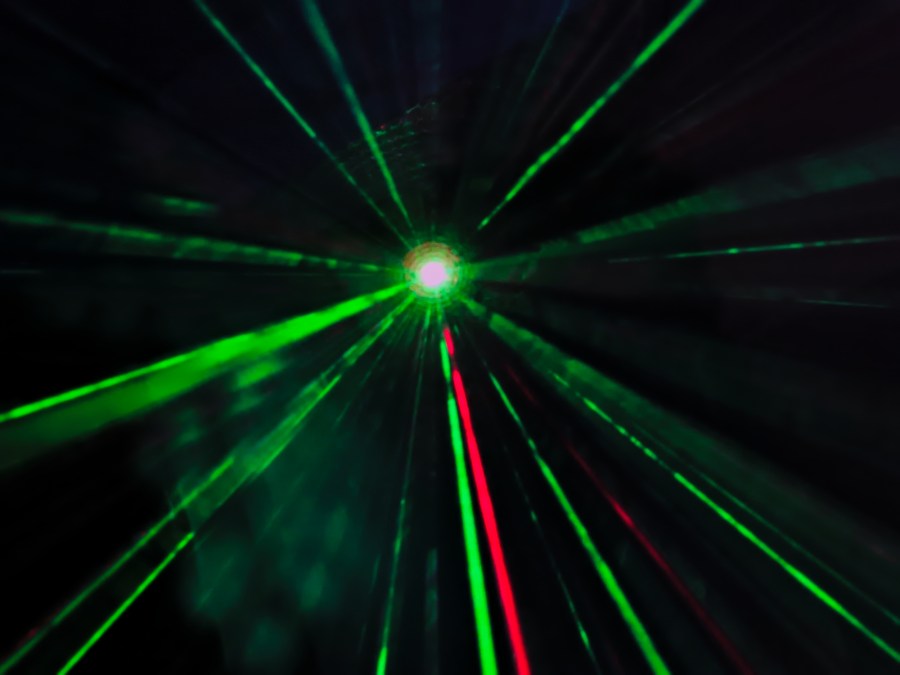 laser beams in green and red colors reflecting in the mist