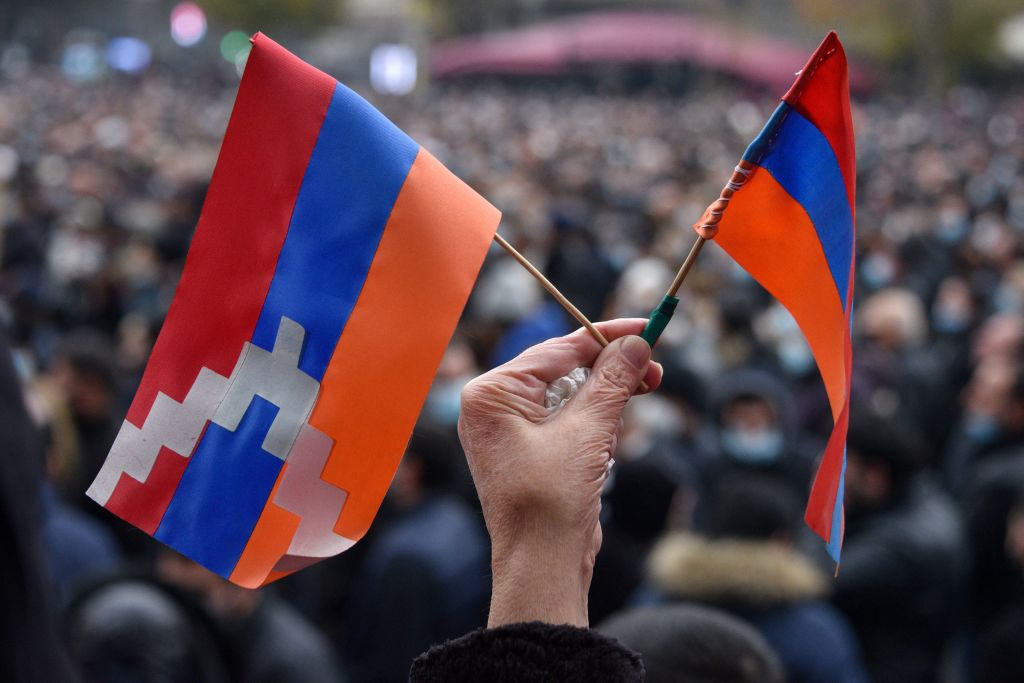 A woman holds a flag of the Republic of Artsakh and an Armenian flag during a rally in Yerevan, Armenia on December 5, 2020. (Getty Images)
