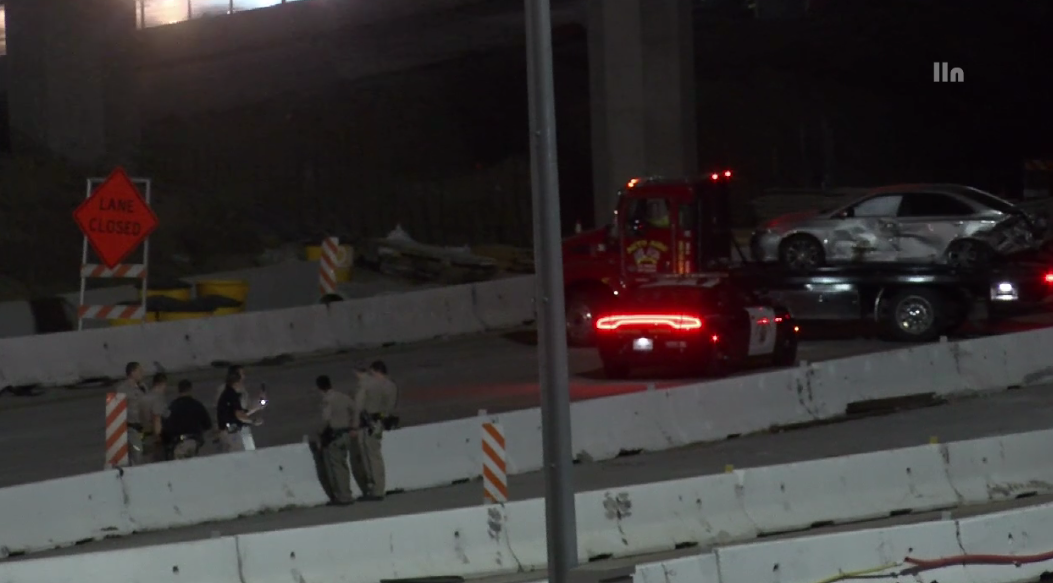 A sedan with major damage is towed from the scene of a road-rage shooting and crash in Corona on April 30, 2023. (LOUDLABS)