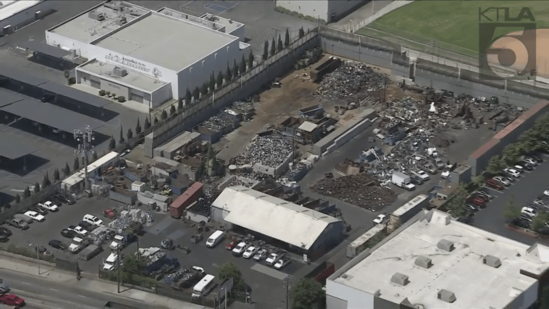 An aerial photo from Sky5 shows Jordan High School (left) next to Atlas Iron and Metal Corp. in Watts on June 21, 2023. (KTLA)