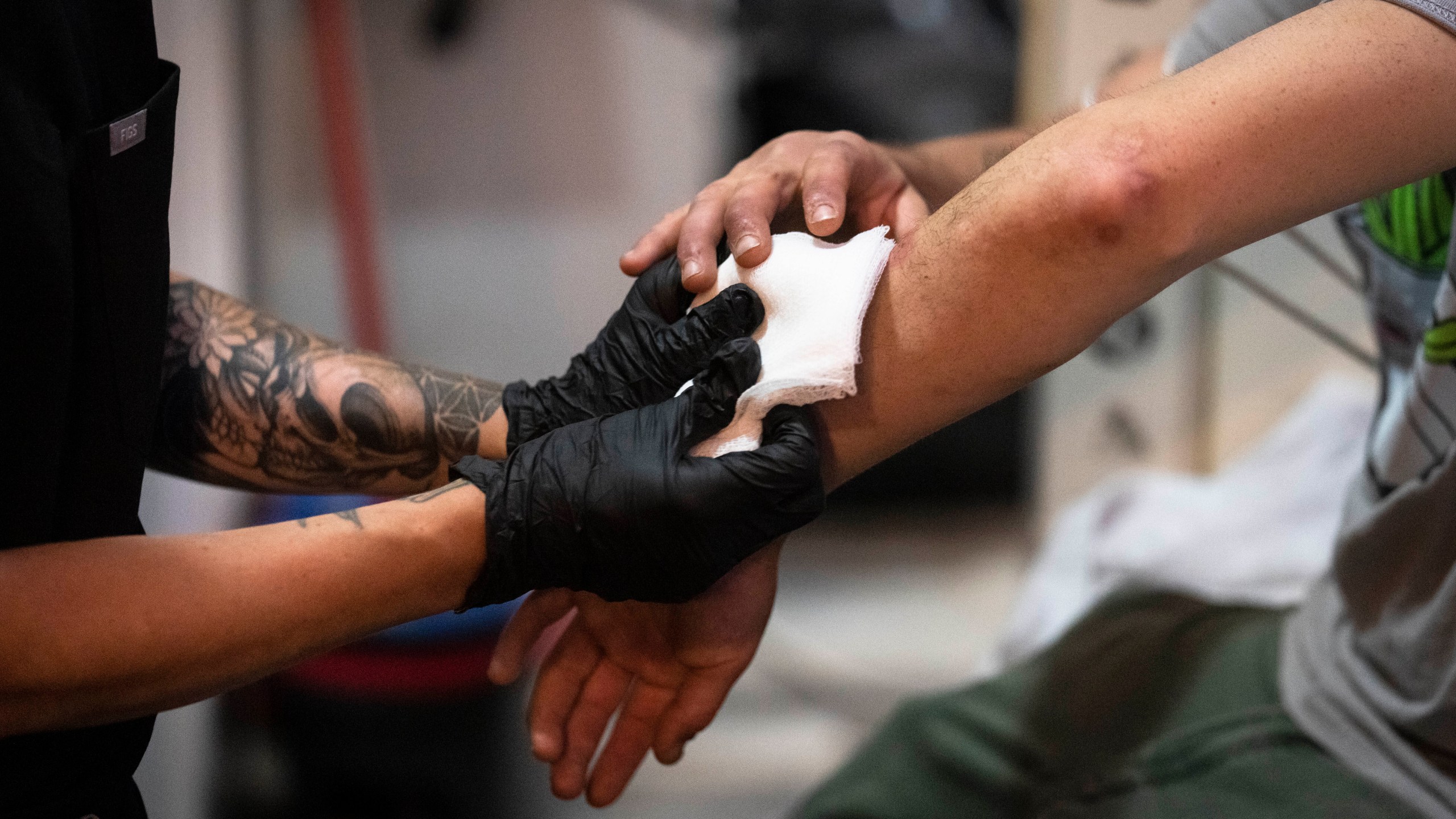 FILE - Volunteer registered nurse Jennifer D'Angelo treats Patrick C.'s skin wounds in a screened off section of the Savage Sisters' community outreach storefront in the Kensington neighborhood of Philadelphia, May 24, 2023. Xylazine, a powerful animal sedative that's moving through the illicit drug supply is complicating the U.S. response to the opioid crisis, causing gruesome skin wounds and scrambling longstanding methods for treating addiction and reversing overdoses. Federal officials are calling for more testing and research on xylazine, the powerful animal sedative that's spreading through the nation's illicit drug supply. (AP Photo/Matt Rourke, File)