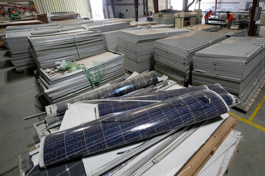 Workers take apart solar panels as they begin the recycling process at We Recycle Solar on Tuesday, June 6, 2023, in Yuma, Ariz. North America’s first utility-scale solar panel recycling plant opened to address what founders of the company call a “tsunami” of solar waste, as technology that became popular in the early 2000s rapidly scales up. (AP Photo/Gregory Bull)