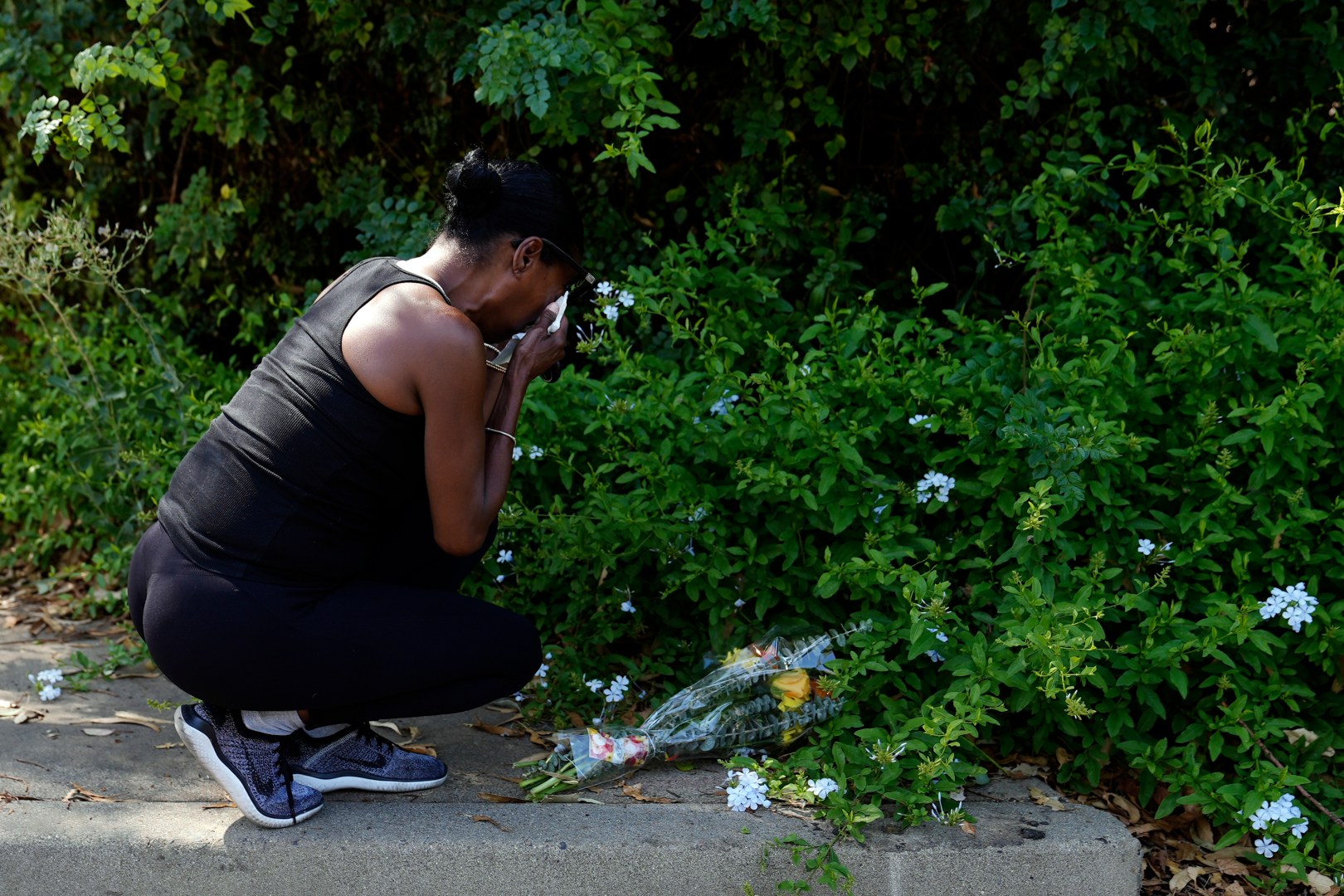 Lisa, only first name given, grieves after placing flowers near the scene of a mass shooting at Cook's Corner, a biker bar in rural Trabuco Canyon, Calif., Thursday, Aug. 24, 2023. (AP Photo/Jae C. Hong)