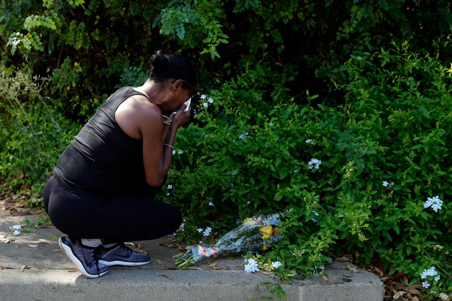 Lisa, only first name given, grieves after placing flowers near the scene of a mass shooting at Cook's Corner, a biker bar in rural Trabuco Canyon, Calif., Thursday, Aug. 24, 2023. (AP Photo/Jae C. Hong)