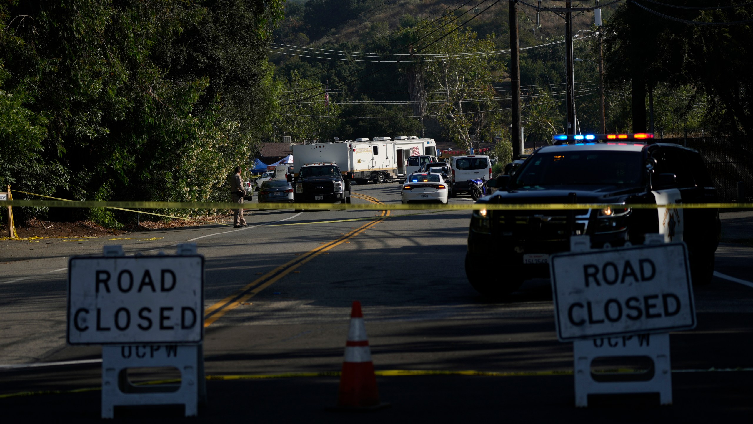 CAPTION CORRECTION: CORRECTS NAME OF BAR: Road closure signs are place at the scene of a mass shooting at Cook's Corner, Thursday, Aug. 24, 2023, in Trabuco Canyon, Calif. Gunfire at a popular Southern California biker bar killed three people and wounded several others Wednesday, and the gunman — believed to be a retired law enforcement officer — was fatally shot by deputies, authorities said. (AP Photo/Jae C. Hong)