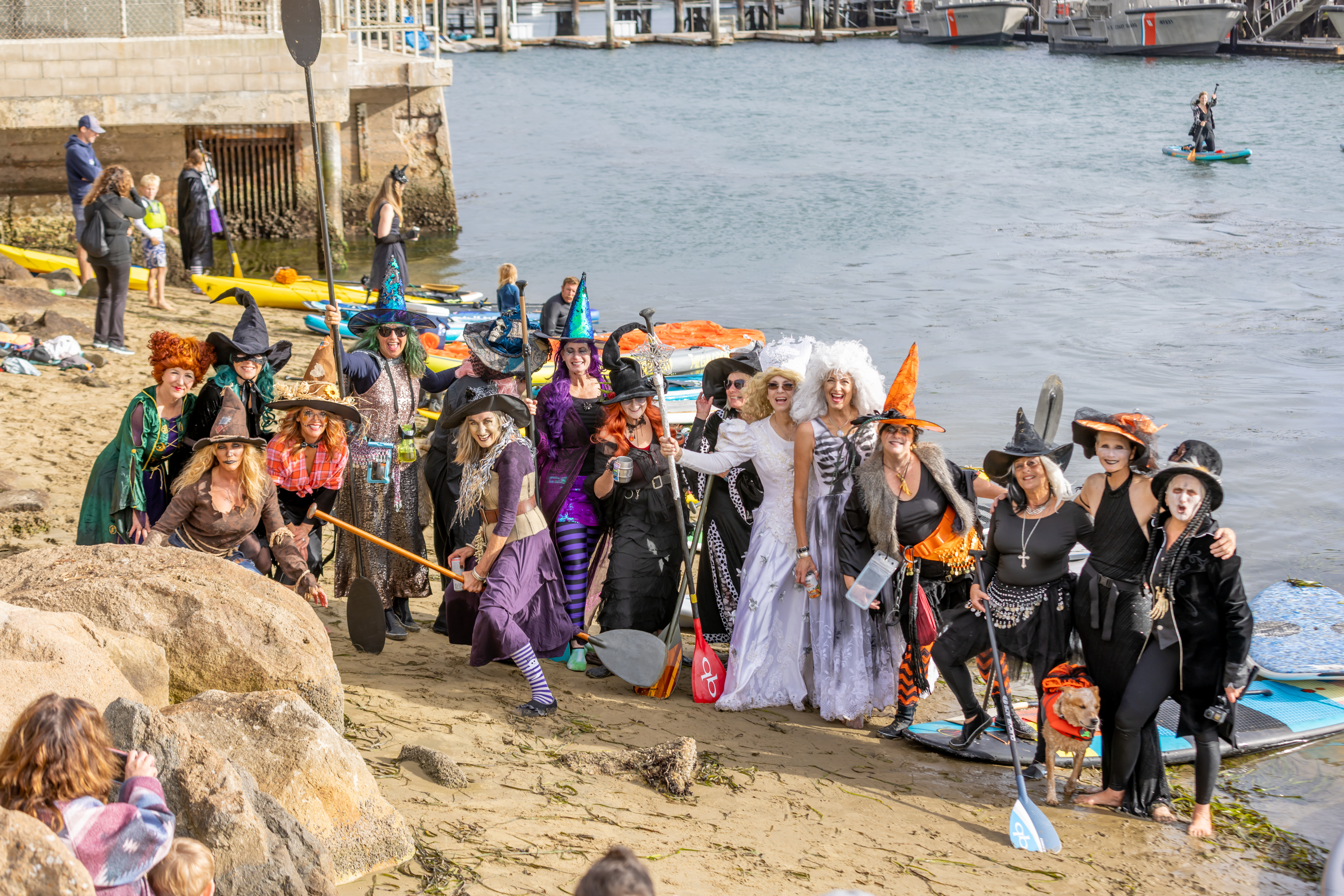 Dozens of people pose on the beach after the annual Morro Bay Witches and Warlocks Paddle. (John DeBacker)