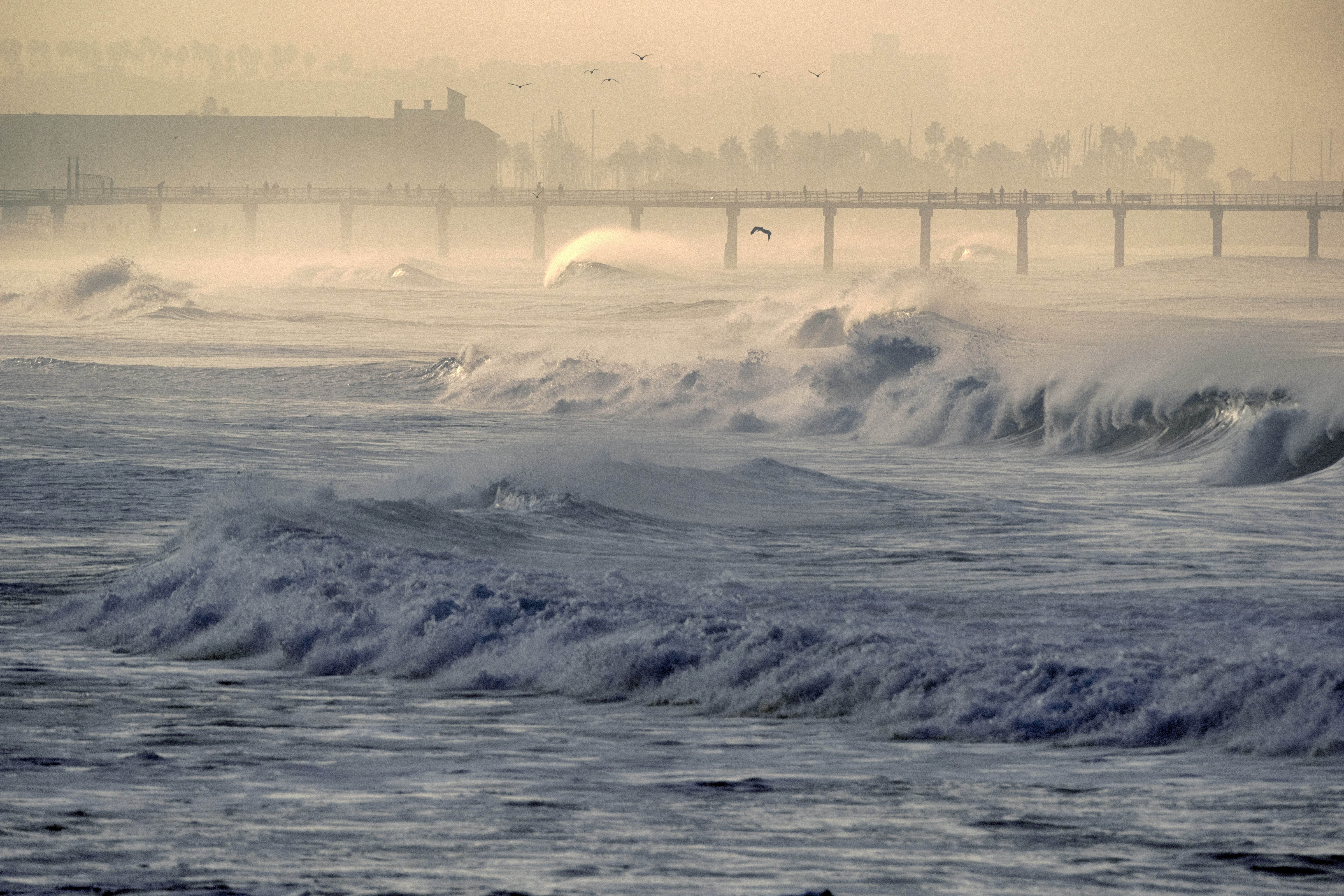 Hermosa beach pier is see as rough surf breaks along the beach in Manhattan beach, Calif. on Thursday, Dec. 28, 2023. The National Weather Service has issued high surf warnings for much of the West Coast and parts of Hawaii, describing the waves and rip currents expected to hit certain coastlines as potentially dangerous and life-threatening.(AP Photo/Richard Vogel)
