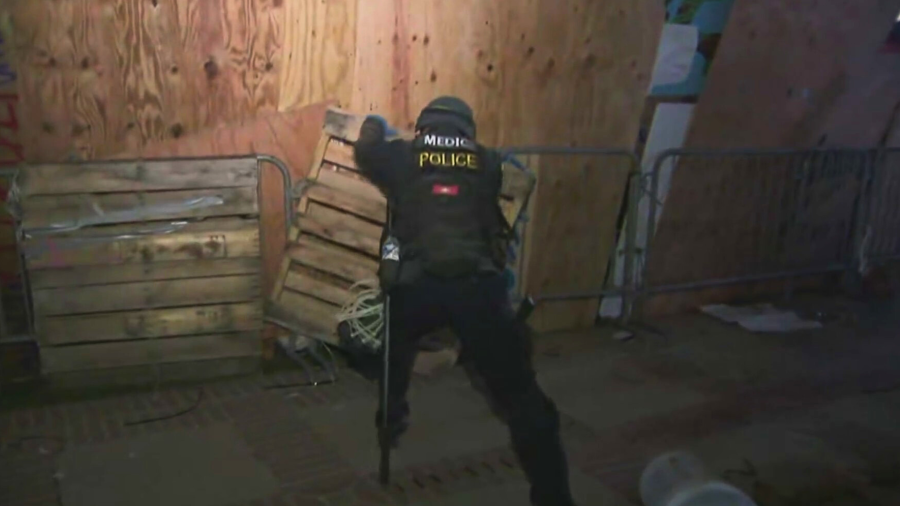 A police officers begins to tear down a pro-Palestinian encampment at UCLA on May 2, 2024.