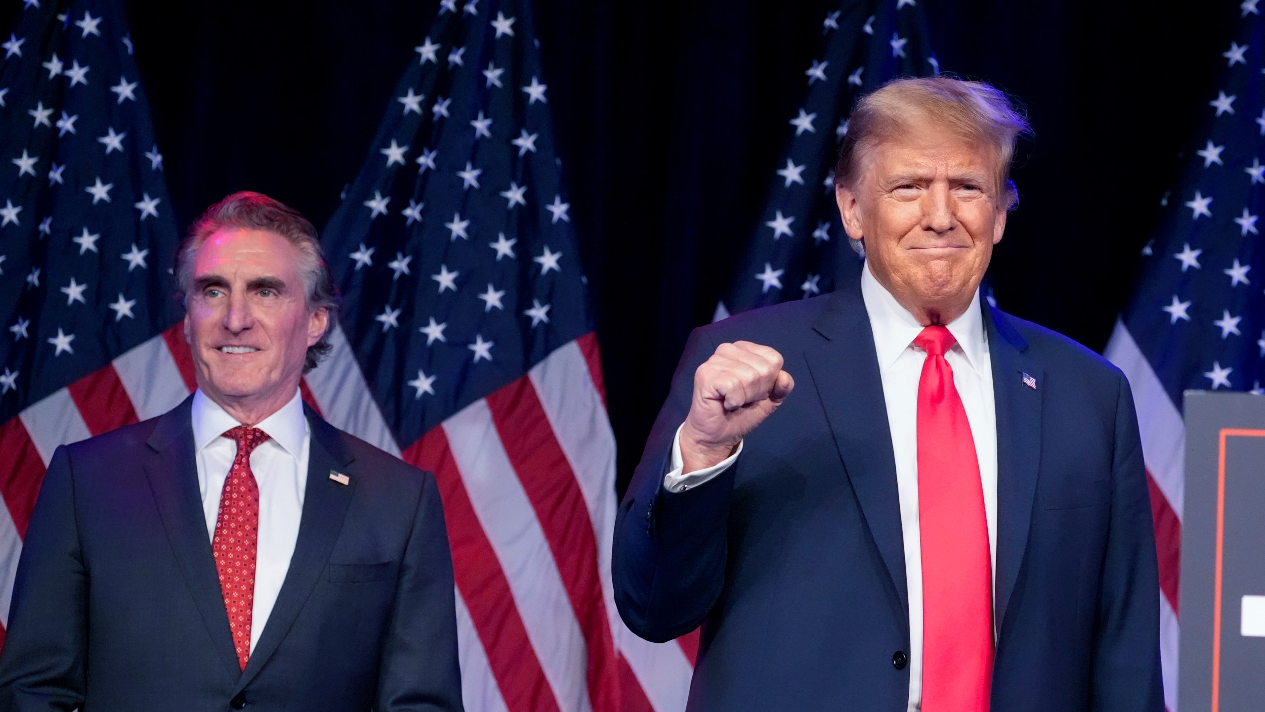 FILE - Republican presidential candidate former President Donald Trump arrives to speak at a caucus night rally in Las Vegas, Feb. 8, 2024, as North Dakota Gov. Doug Burgum watches. (AP Photo/Alex Brandon, File)