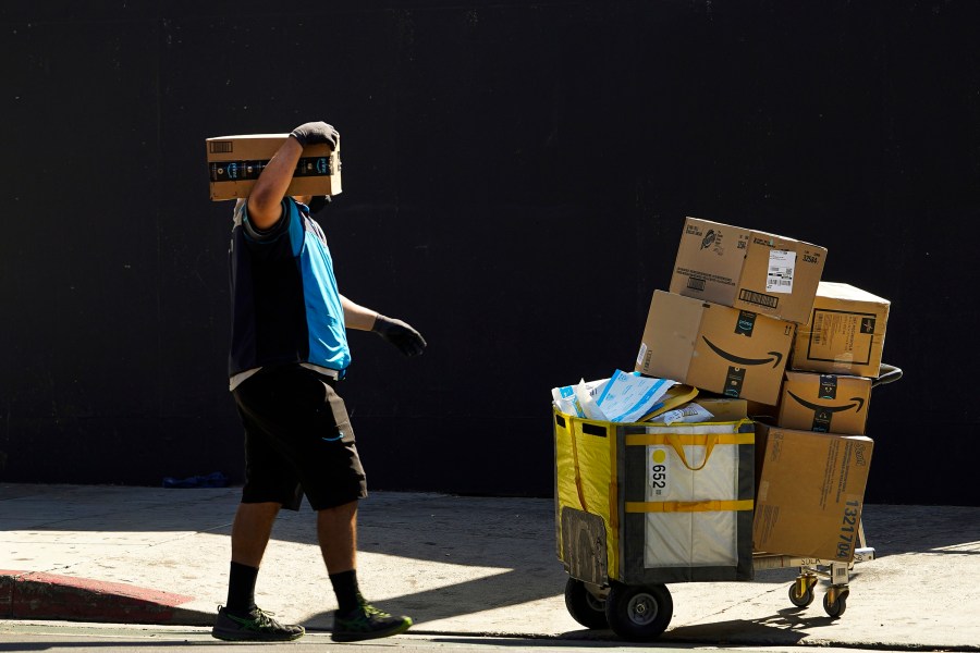 An Amazon worker delivers packages in Los Angeles on Oct. 1, 2020. July sales events have become a seasonal revenue driver for the retail industry since Amazon launched its first Prime Day back in 2015. (AP Photo/Damian Dovarganes, File)