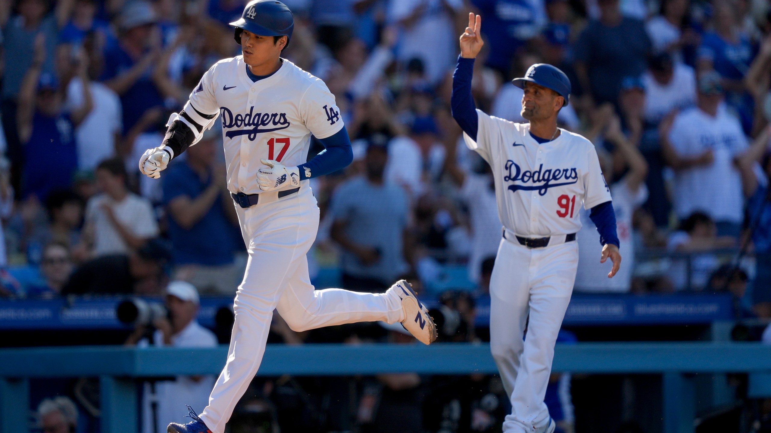 Los Angeles Dodgers designated hitter Shohei Ohtani, left, celebrates his solo home run with third base coach Dino Abel, right, during the fifth inning of a baseball game against the Boston Red Sox, Sunday, July 21, 2024, in Los Angeles. (AP Photo/Ryan Sun)