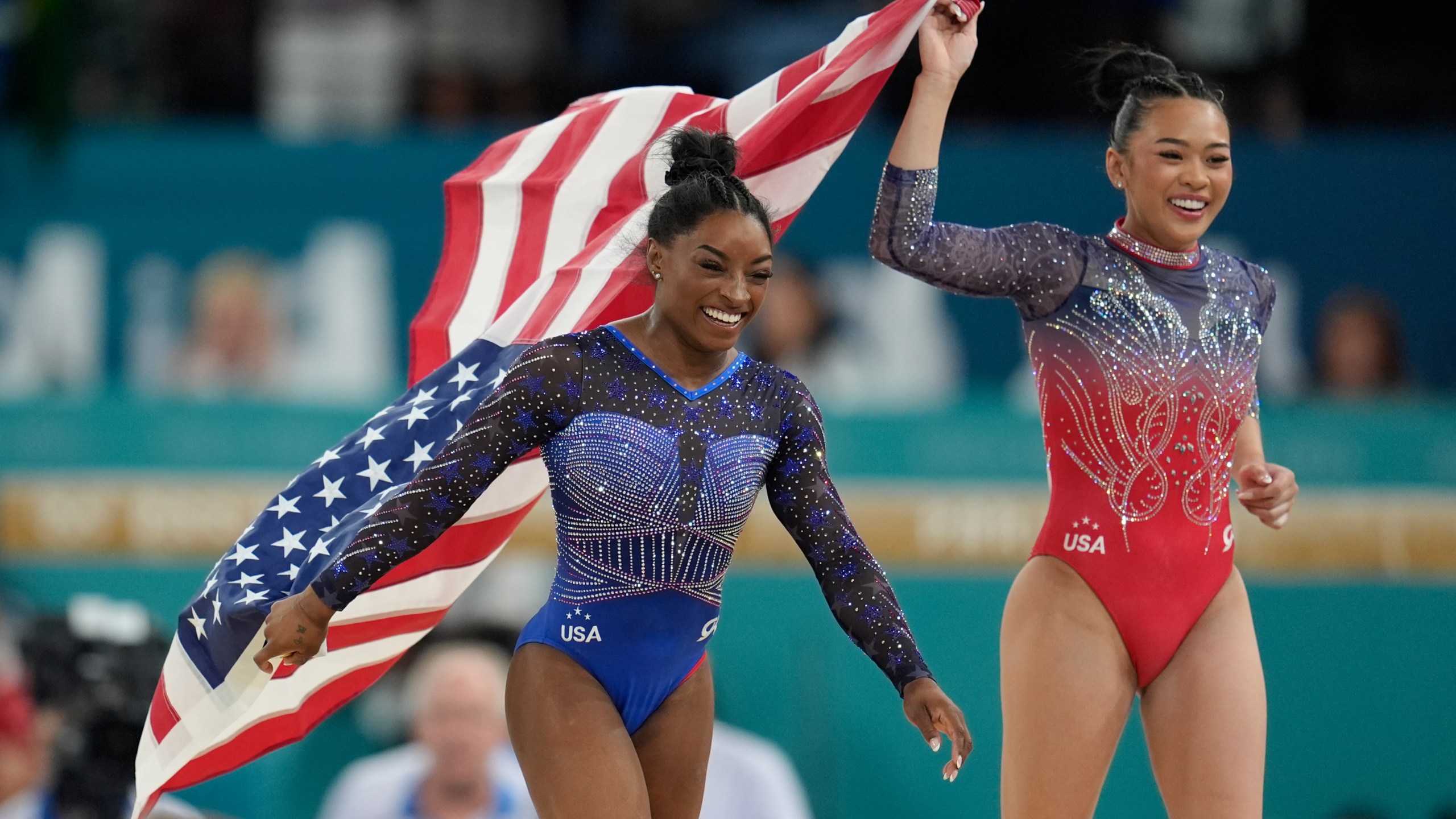Simone Biles, left, celebrates with teammate Suni Lee, of the United States, after winning the gold and bronze medals respectively in the women's artistic gymnastics all-around finals in Bercy Arena at the 2024 Summer Olympics, Thursday, Aug. 1, 2024, in Paris, France. (AP Photo/Abbie Parr)
