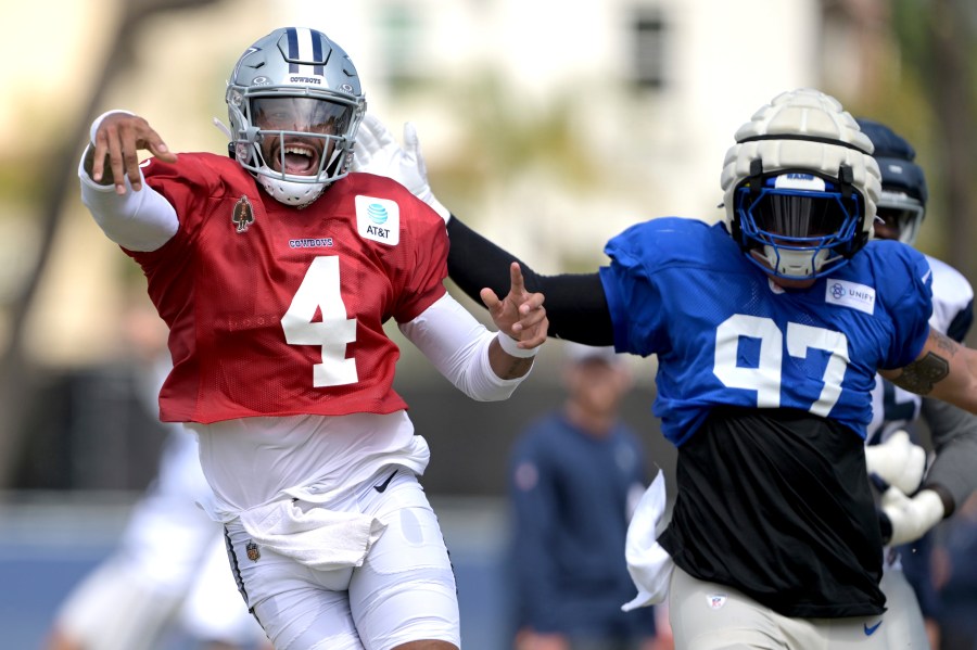 Dallas Cowboys quarterback Dak Prescott (4) looks for an open receiver as he is defended by Los Angeles Rams linebacker Michael Hoech during a joint practice at the Cowboy's NFL football training camp Thursday, Aug. 8, 2024, in Oxnard, Calif. (AP Photo/Jayne Kamin-Oncea)