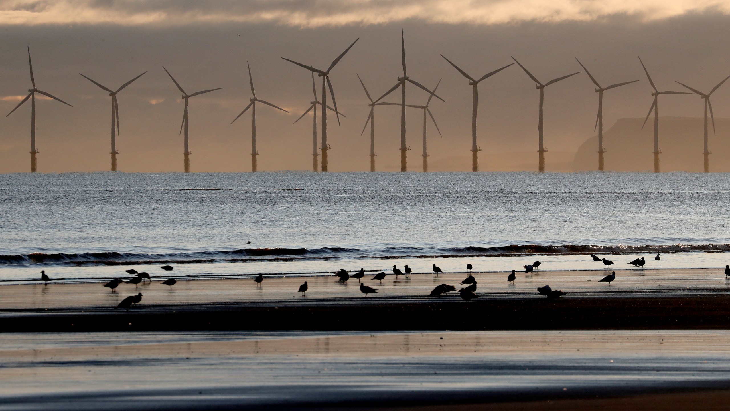 FILE - An offshore wind farm is visible from the beach in Hartlepool, England, Nov. 12, 2019. (AP Photo/Frank Augstein, File)