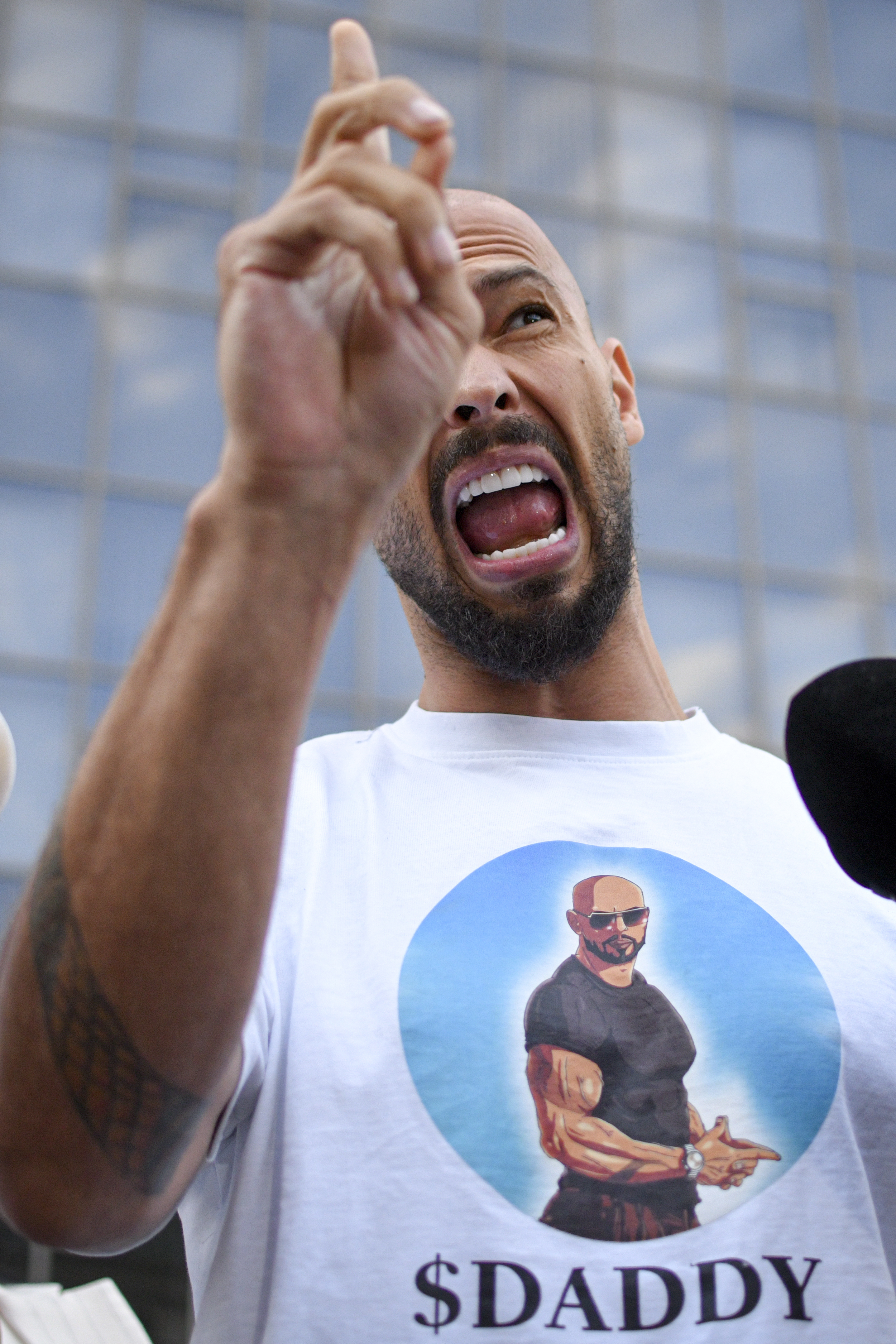 Andrew Tate speaks to media outside the Bucharest Tribunal after being placed under house arrest, in Bucharest, Romania, Thursday, Aug. 22, 2024. A court in Romania's capital on Thursday placed the divisive internet influencer Andrew Tate under house arrest for 30 days, as prosecutors investigate a sprawling new case that involves allegations of human trafficking of minors and sex with a minor. (AP Photo/Alexandru Dobre)