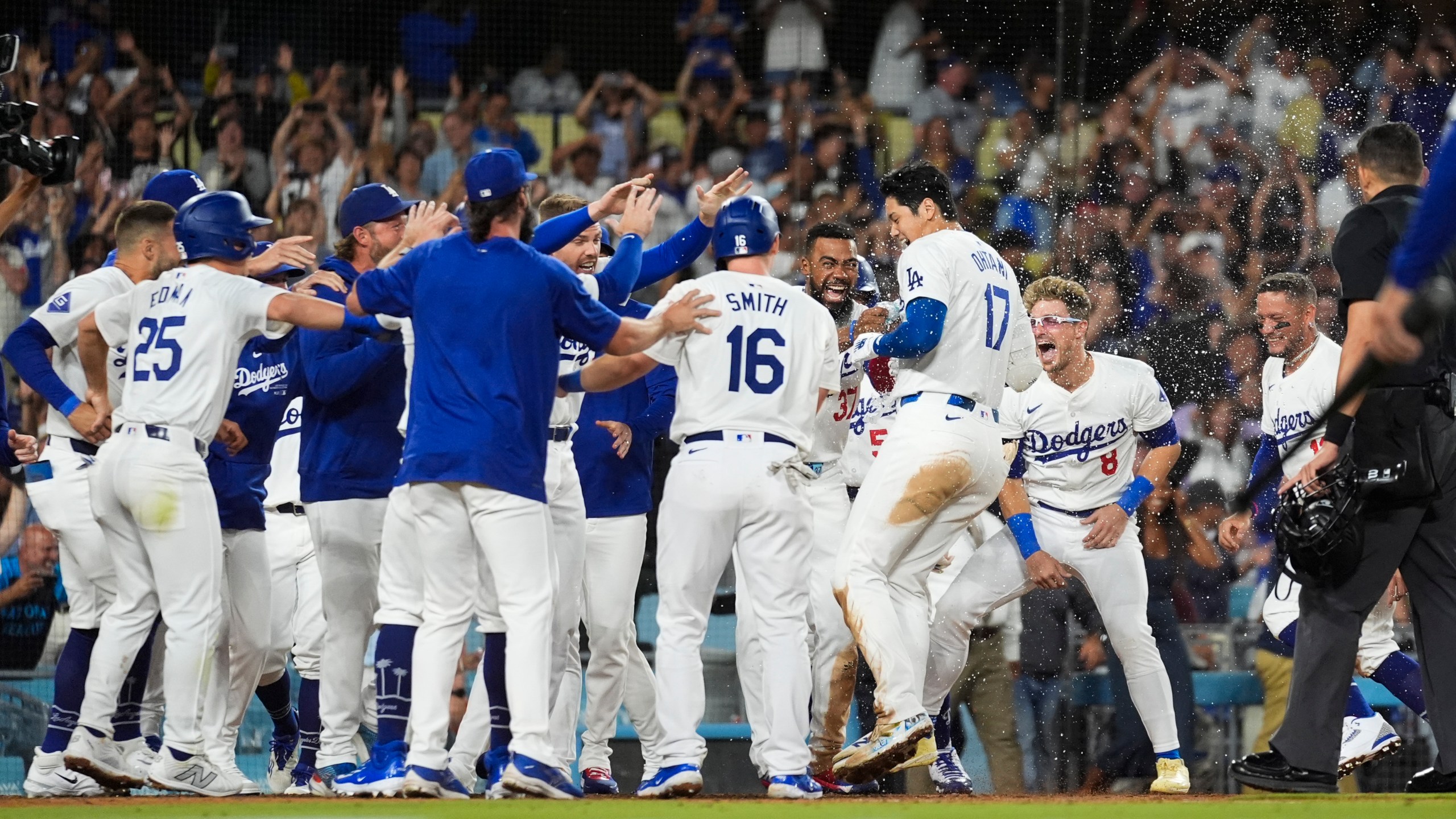 Los Angeles Dodgers designated hitter Shohei Ohtani (17) celebrates with teammates after hitting a grand slam during the ninth inning of a baseball game against the Tampa Bay Rays in Los Angeles, Friday, Aug. 23, 2024. The Dodgers won 7-3. (AP Photo/Ashley Landis)