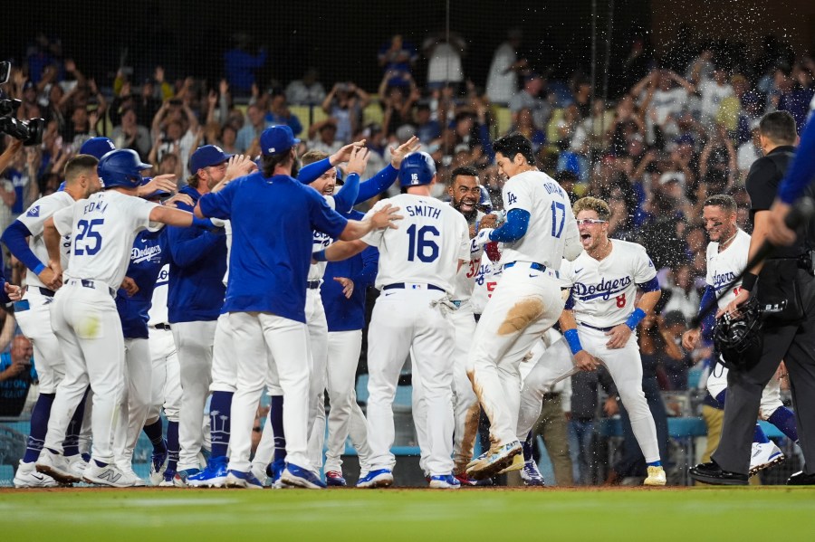 Los Angeles Dodgers designated hitter Shohei Ohtani (17) celebrates with teammates after hitting a grand slam during the ninth inning of a baseball game against the Tampa Bay Rays in Los Angeles, Friday, Aug. 23, 2024. The Dodgers won 7-3. (AP Photo/Ashley Landis)