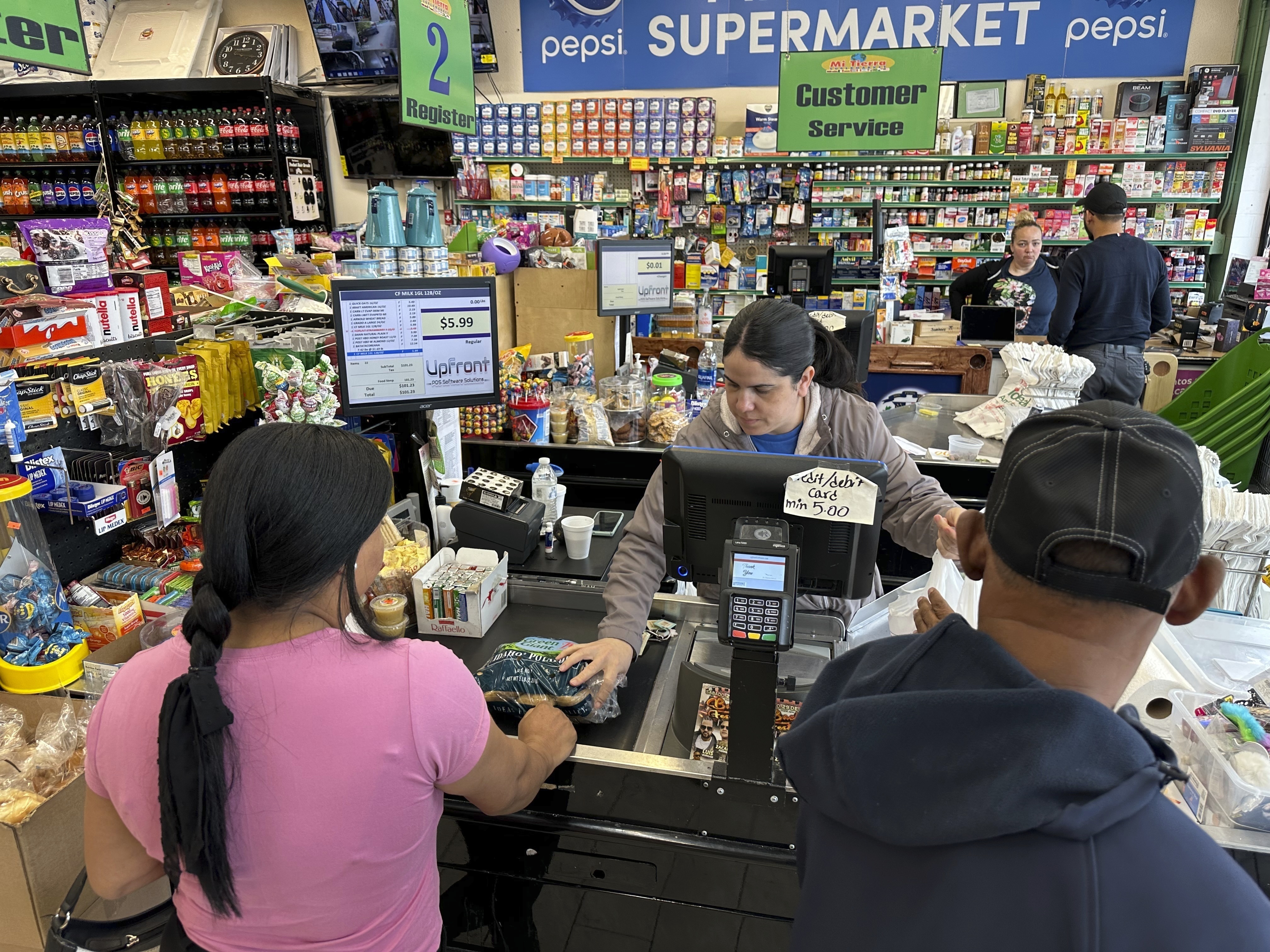 FILE - Cashier Rosa Dilone helps customers at Mi Tierra Supermarket in Hazleton, Pa., on May 16, 2024. (AP Photo/Mark Scolforo, File)
