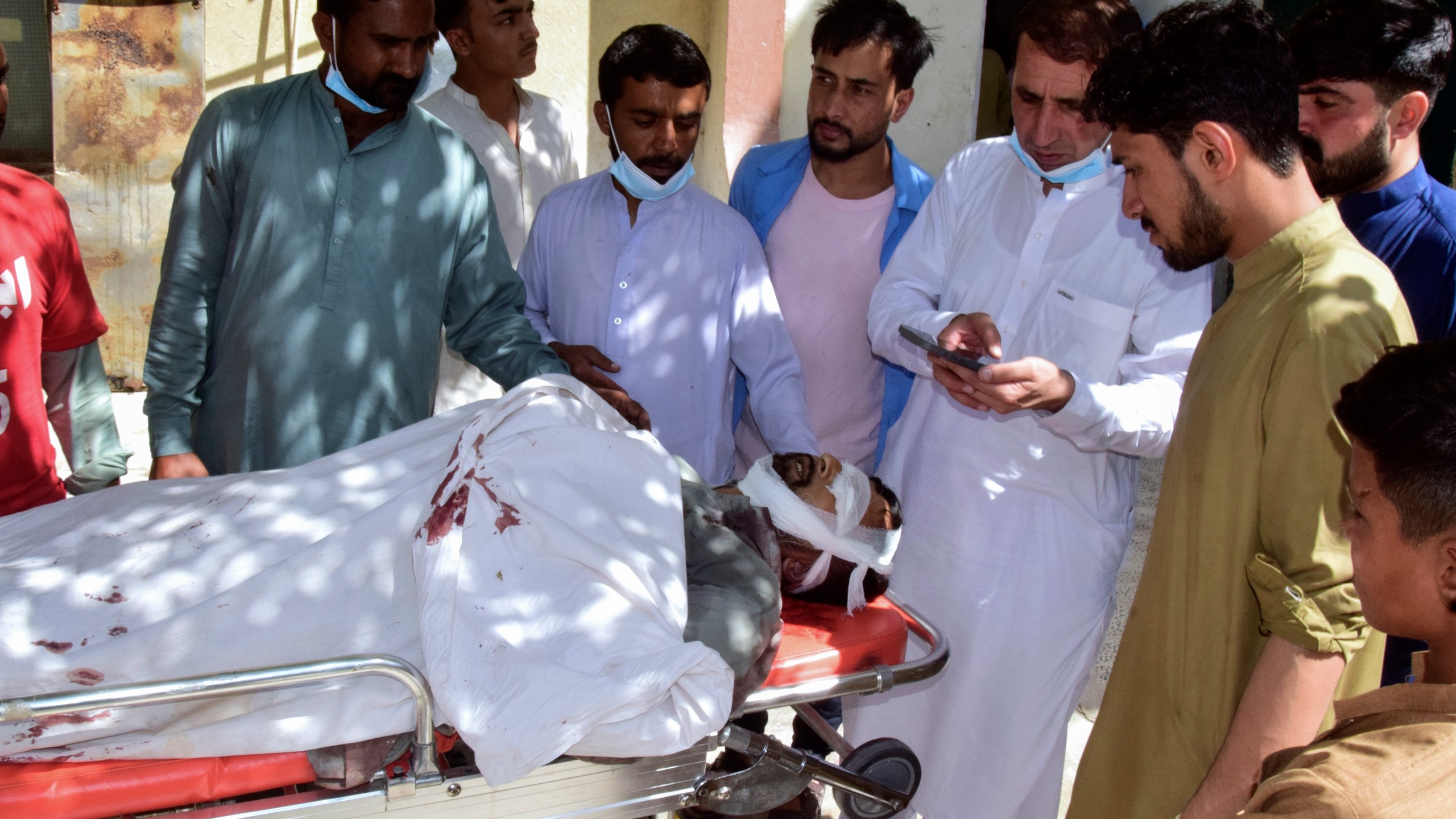 Relatives gather around a body of a passenger, killed by gunmen at a highway in Musakhail, as they wait for transportation at a hospital, in Quetta, Pakistan, Monday, Aug. 26, 2024. (AP Photo/Arshad Butt)