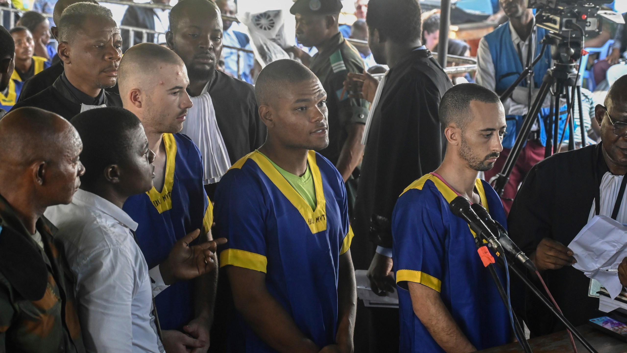 FILE - From left, Tyler Thompson Jr., Marcel Malanga and Benjamin Reuben Zalman-Polun, all American citizens, face the court in Kinshasa, Congo, with 52 other defendants, June 7, 2024, accused of a role in the attempted coup in Congo led by little-known opposition figure Christian Malanga in which six people were killed. (AP Photo/Samy Ntumba Shambuyi, File)