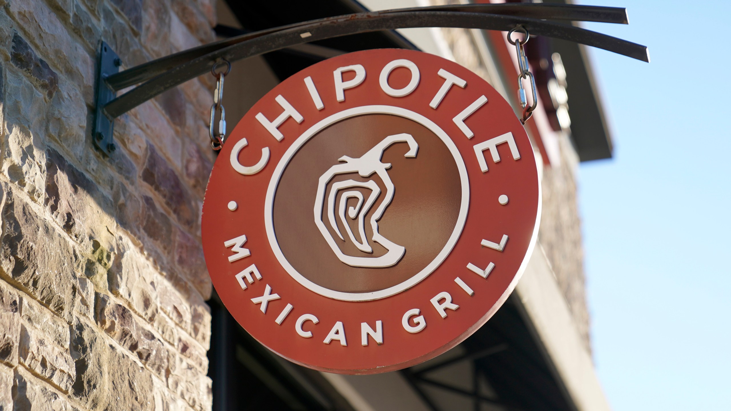 FILE - The Chipotle Mexican Grill logo hangs outside a restaurant location, Dec. 20, 2022, in Westwood, Mass. . (AP Photo/Steven Senne, File)