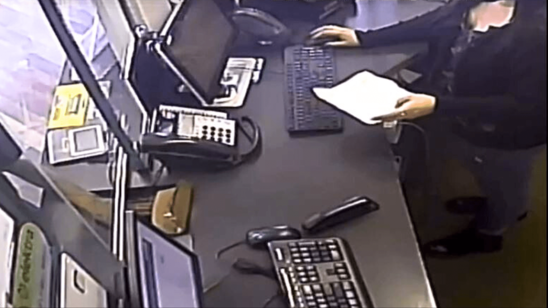 The suspect hands a note to the teller and pushes a brown papaer bag toward her before brandishing a weapon during an attempted robbery in Santa Ana on Aug. 7, 2024. (Santa Ana Police Department)