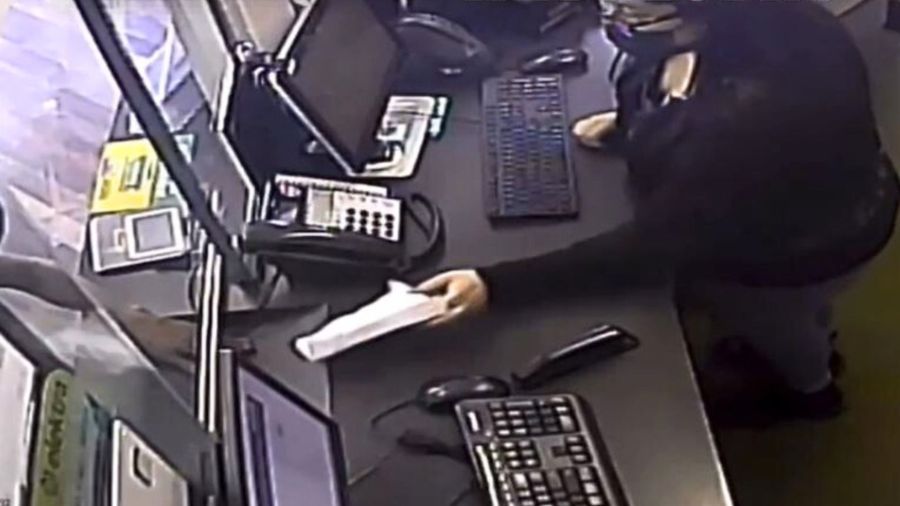 The suspect hands a note to the teller before brandishing a weapon during an attempted robbery in Santa Ana on Aug. 7, 2024. (Santa Ana Police Department)