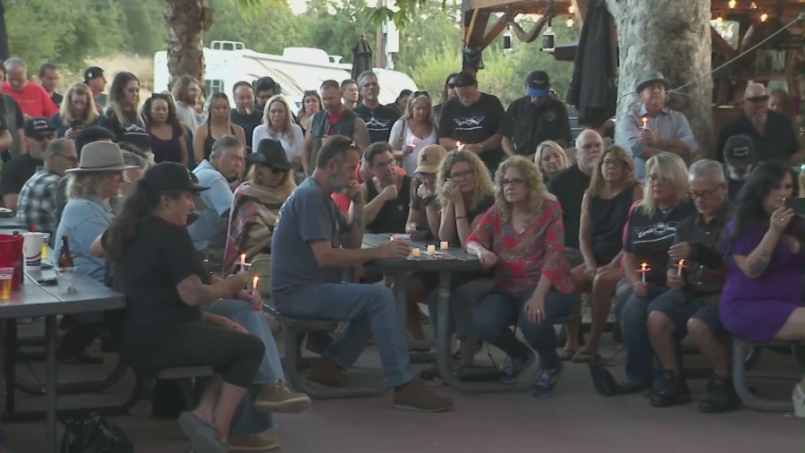 Community members and patrons gathered at Cook's Corner biker bar on August 23, 2024, for a prayer service and candlelight vigil honoring the victims of a 2023 mass shooting. (KTLA)