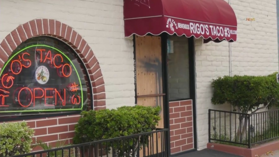 Another nearby restaurant is seen boarded up after burglars smashed the front door. (KTLA)