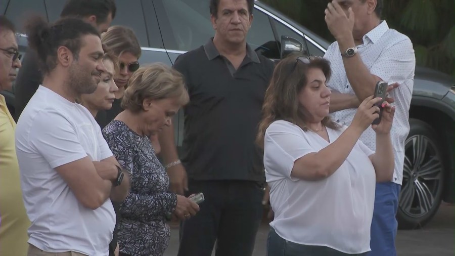 Loved ones gathered near a growing memorial outside a Woodland Hills clinic honoring Hamid Mirshojae on August 24, 2024. (KTLA)