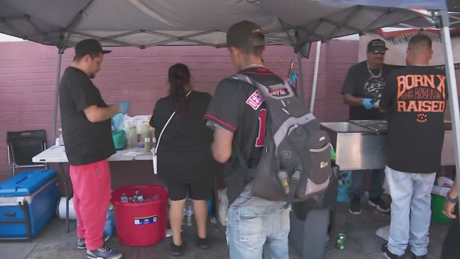 Long lines wrap around the block as hungry Skid Row residents await Chris Bailey's free meals. (KTLA)