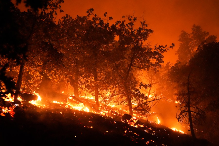 The Bridge Fire burns near homes in Wrightwood, Calif., Tuesday, Sept. 10, 2024. (AP Photo/Jae C. Hong)