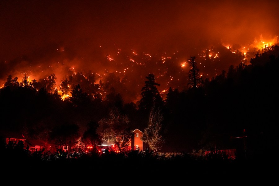 Firetrucks are seen around a building as scorched trees smolder during the Bridge Fire in Wrightwood, Calif., Wednesday, Sept. 11, 2024. (AP Photo/Jae C. Hong)
