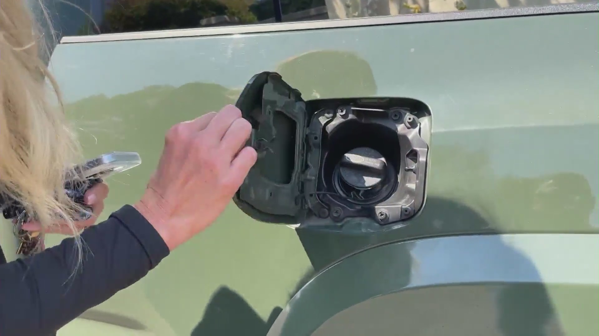 Heather Velasco shows KTLA her damaged gas cap after thieves drilled two holes into the fuel tank to steal gasoline. (KTLA)