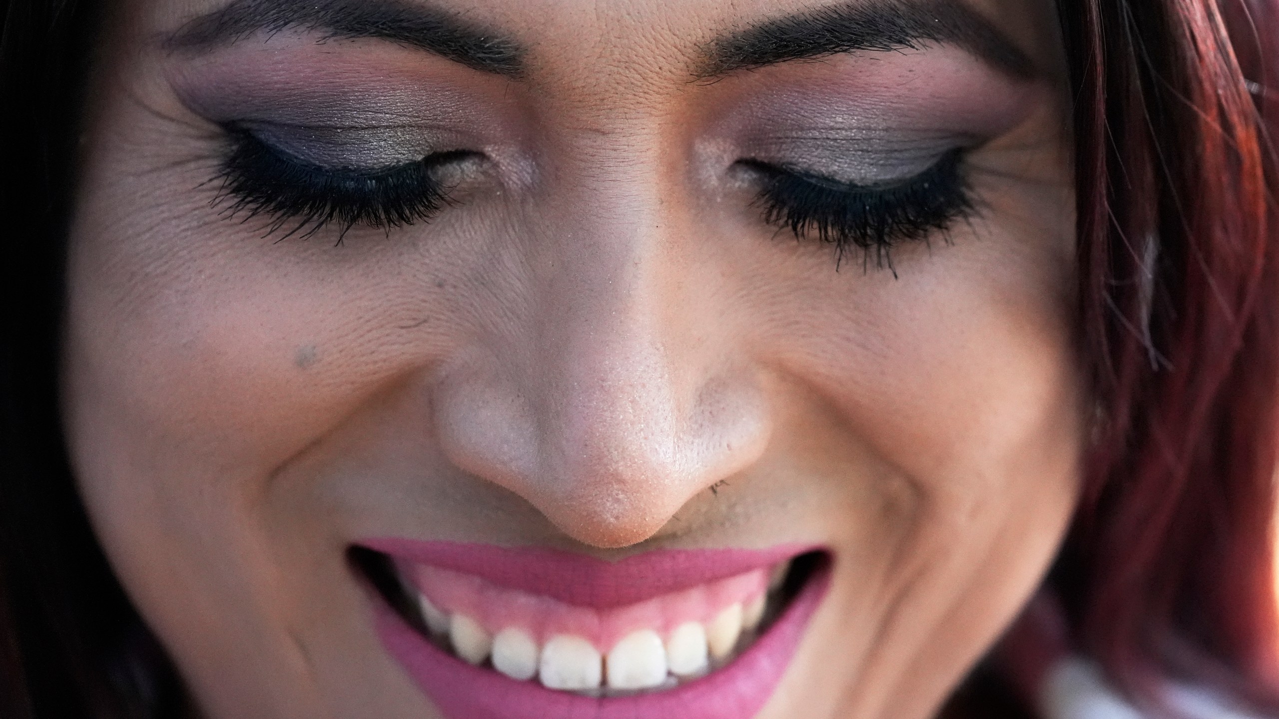Julieth Luna Garcia, a transgender woman from El Salvador, smiles as she listens to Drew Heckman from Rainbow Railroad at Horner Park in Chicago, Monday, Sept. 30, 2024. (AP Photo/Nam Y. Huh)