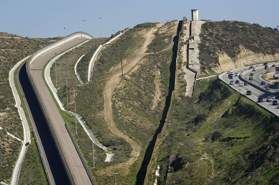 Vehicles drive along a highway next to the border wall that separates the U.S. and Mexico in Tijuana, Mexico, on Thursday, Jan. 26, 2017. (David Maung/Bloomberg via Getty Images)