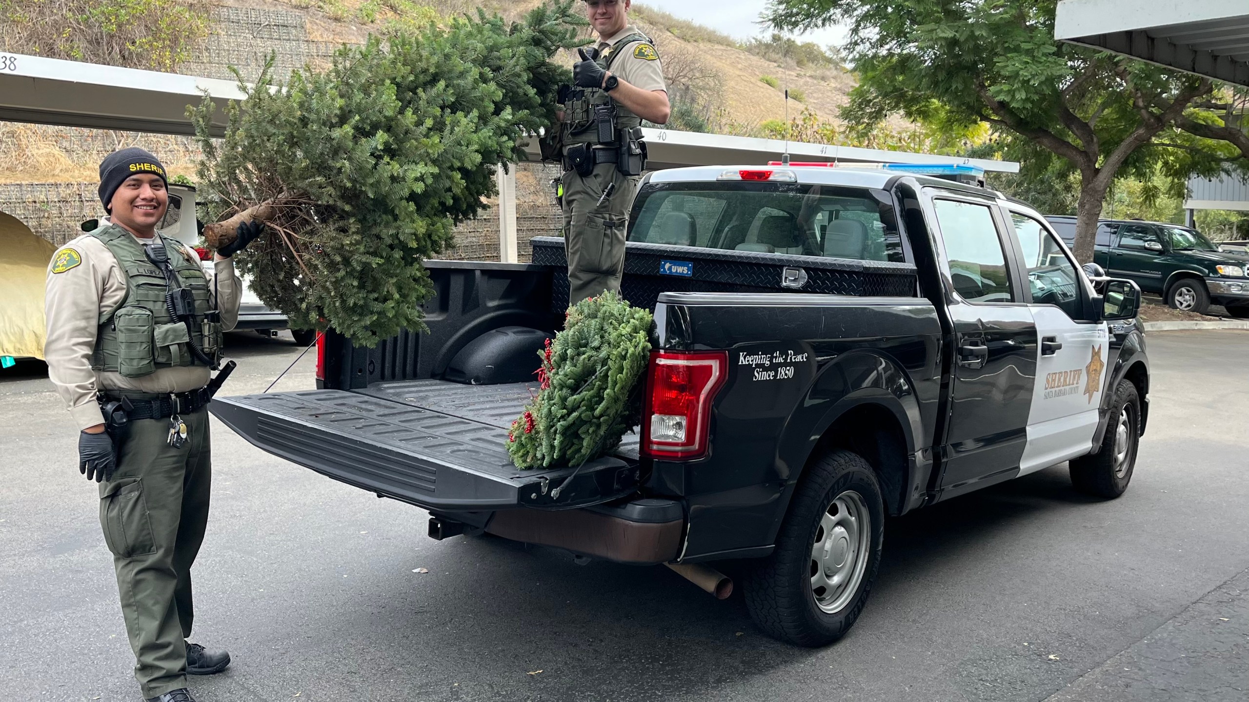 Santa Barbara County Sheriff's deputies pose with a stolen Christmas tree that was recovered on Dec. 11, 2024. (Santa Barbara County Sheriff's Office)